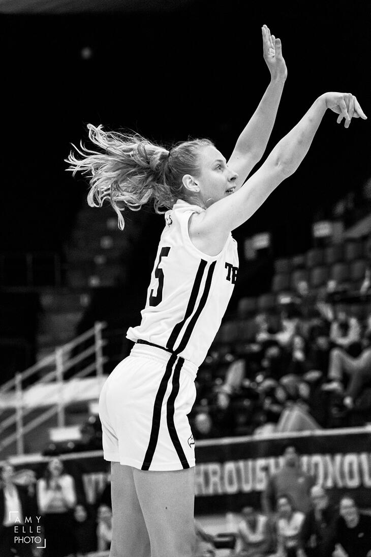 Emily Martindale (UBC Women's Basketball) jumps to make a three point shot