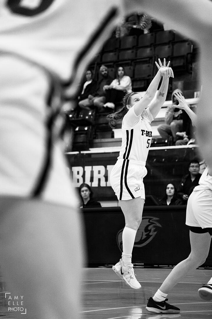 Hailey Counsell (UBC Women's Basketball) jumps to make a three point shot