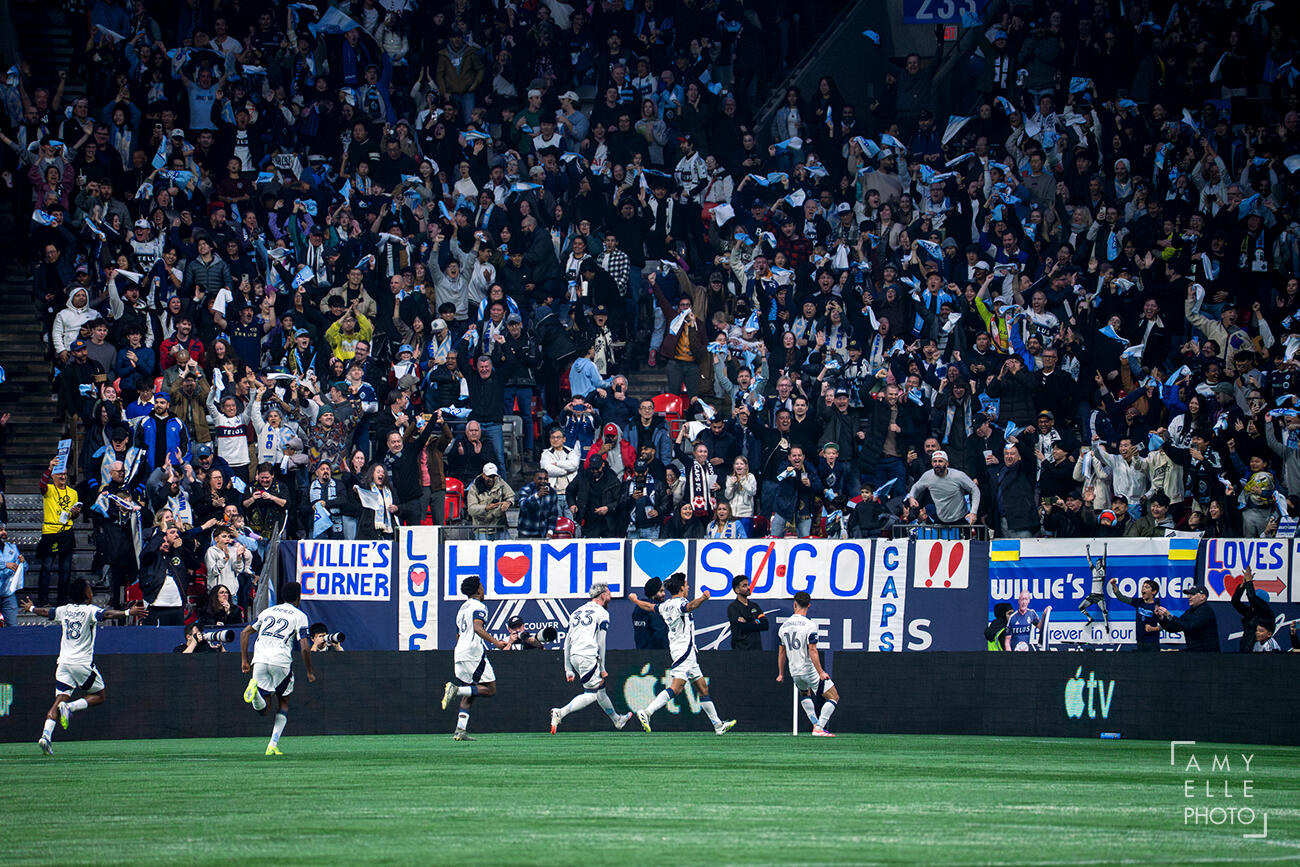 Vancouver Whitecaps FC celebrate after scoring a goal with fan supporters cheering in the background at the 2025 MLS Cup Western Conference finals